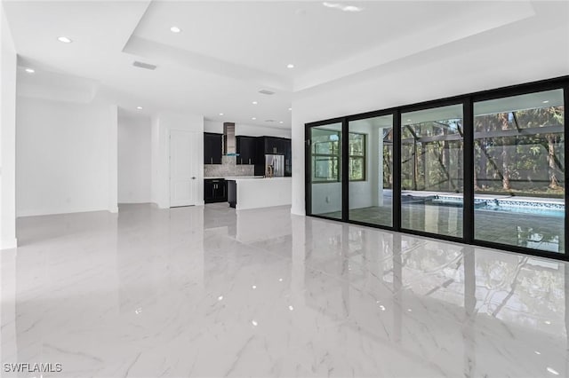 unfurnished living room with a tray ceiling