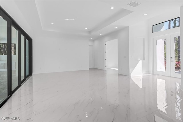 spare room featuring a raised ceiling and french doors