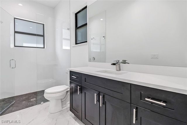 bathroom featuring vanity, toilet, and a shower with shower door