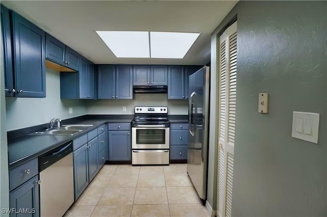 kitchen featuring appliances with stainless steel finishes, a skylight, light tile patterned floors, and sink