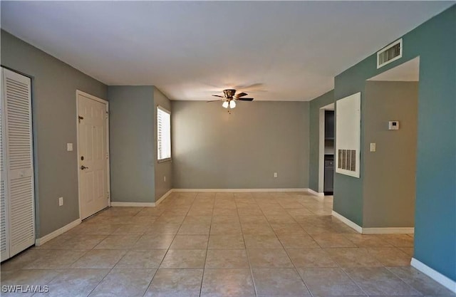 tiled empty room with ceiling fan