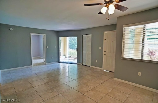 spare room with ceiling fan and light tile patterned flooring