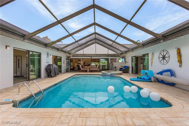 view of swimming pool with glass enclosure, an in ground hot tub, and a patio