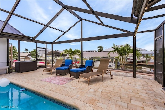 view of patio with glass enclosure and a water view