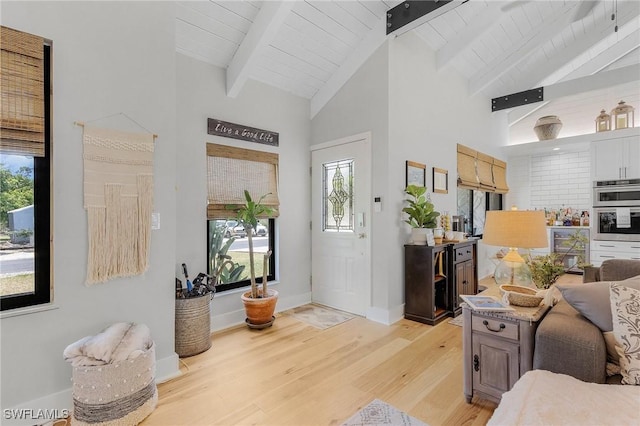 foyer featuring light hardwood / wood-style flooring and lofted ceiling with beams