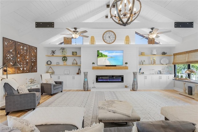 living room with lofted ceiling with beams, built in features, light hardwood / wood-style floors, and ceiling fan with notable chandelier