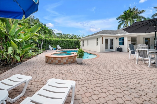 view of patio / terrace with a pool with hot tub and french doors