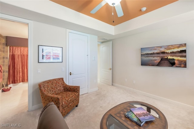 living area featuring ceiling fan and light colored carpet