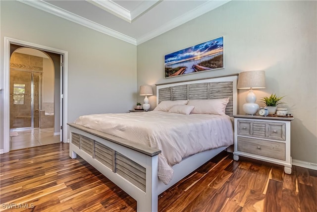 bedroom with ensuite bathroom, dark wood-type flooring, and ornamental molding