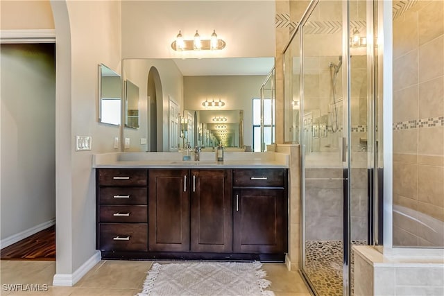 bathroom with tile patterned flooring, vanity, and a shower with door