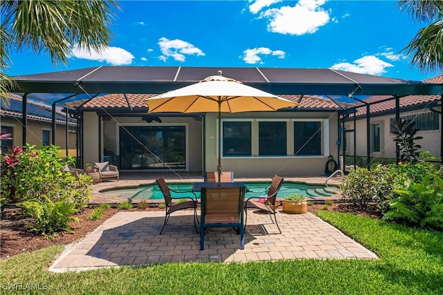 back of property with glass enclosure and a patio area