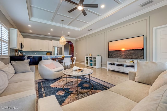 tiled living room with ceiling fan, crown molding, and coffered ceiling