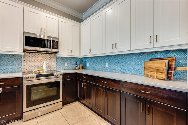 kitchen with white cabinetry, backsplash, crown molding, light tile patterned flooring, and appliances with stainless steel finishes