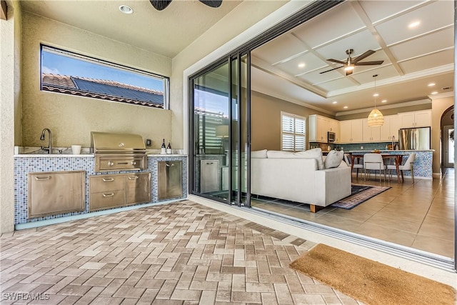 unfurnished living room featuring ceiling fan, ornamental molding, and coffered ceiling