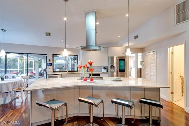 kitchen featuring pendant lighting, decorative backsplash, stainless steel fridge, and white cabinetry