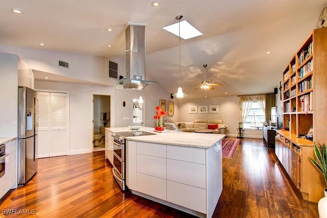 kitchen featuring white cabinetry, lofted ceiling with skylight, extractor fan, a kitchen island, and appliances with stainless steel finishes