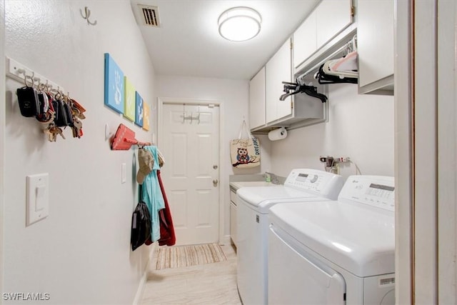 clothes washing area featuring cabinets, washing machine and dryer, and sink