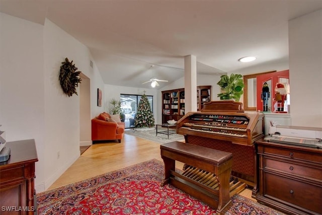 miscellaneous room featuring ceiling fan, light wood-type flooring, and vaulted ceiling