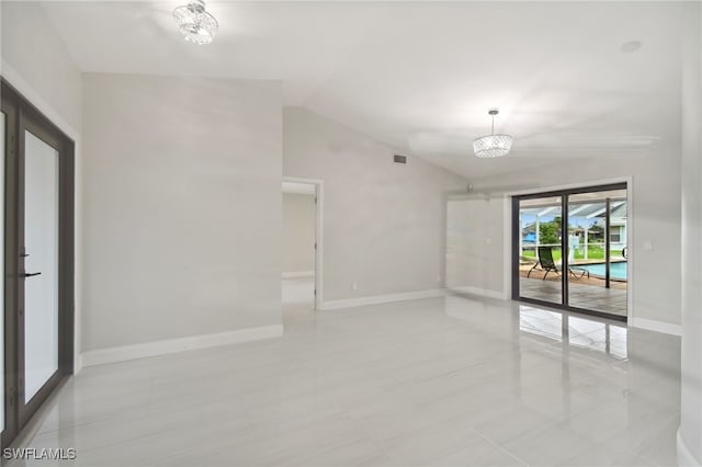 unfurnished room featuring vaulted ceiling, light tile patterned floors, and a chandelier