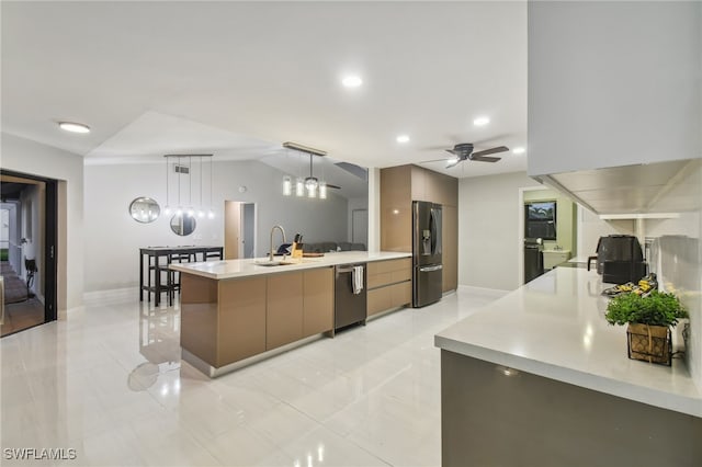 kitchen with appliances with stainless steel finishes, ceiling fan, a spacious island, sink, and decorative light fixtures