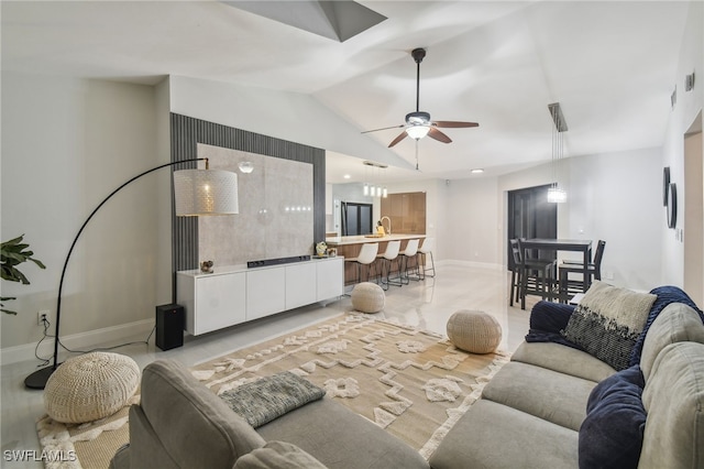 living room with ceiling fan, sink, and vaulted ceiling