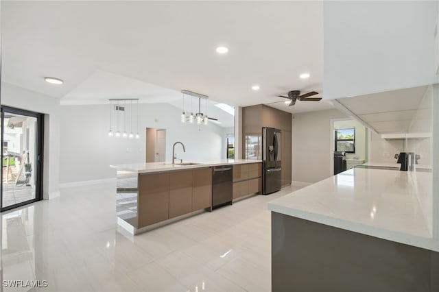 kitchen featuring stainless steel fridge, vaulted ceiling, ceiling fan, sink, and decorative light fixtures