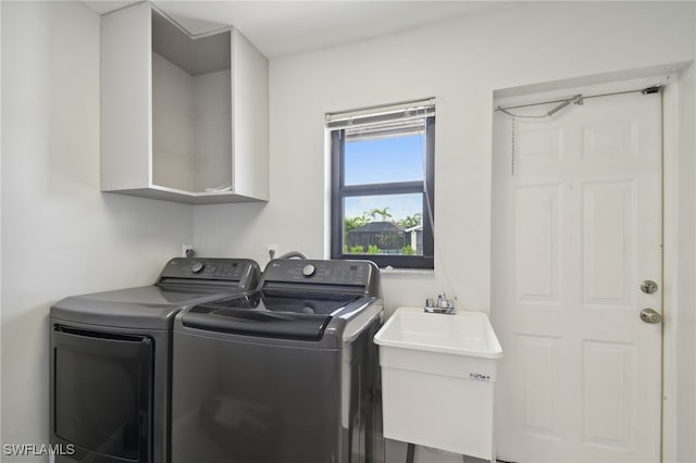 laundry area with independent washer and dryer and sink