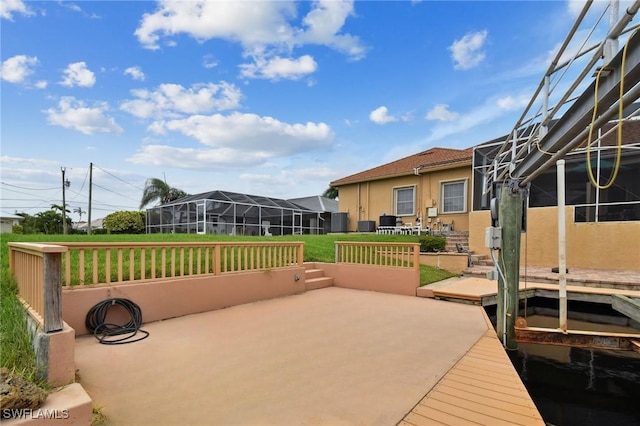 view of patio / terrace featuring a lanai and a dock