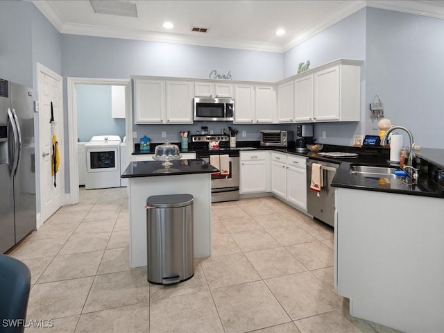 kitchen featuring sink, appliances with stainless steel finishes, white cabinets, washer / dryer, and kitchen peninsula