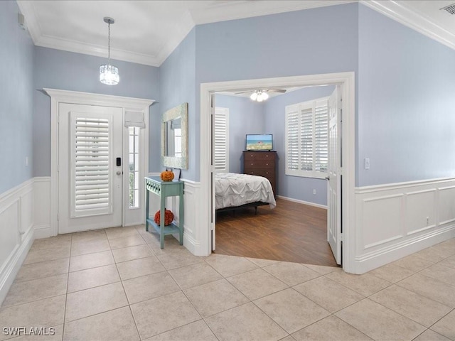 foyer with crown molding and light tile patterned floors