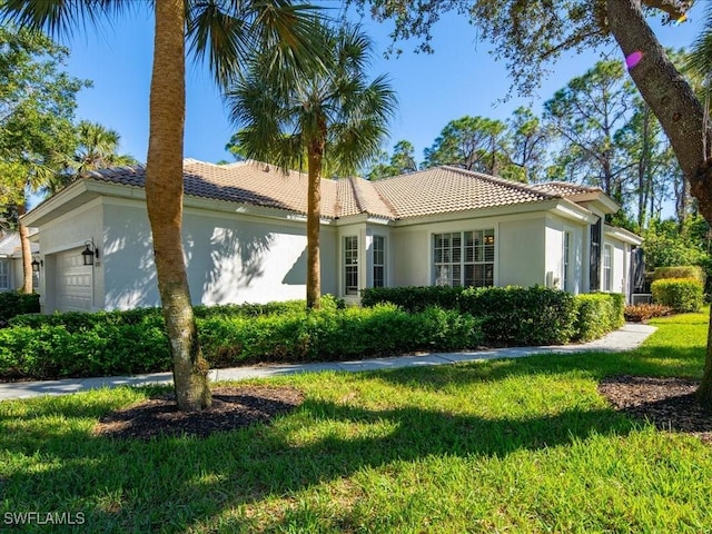 view of home's exterior with a garage and a yard