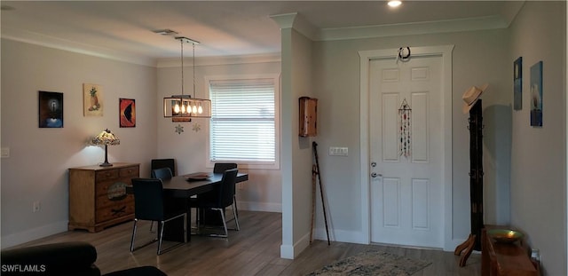 entryway with hardwood / wood-style flooring, a notable chandelier, and crown molding