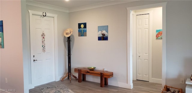 foyer featuring light wood-type flooring and crown molding