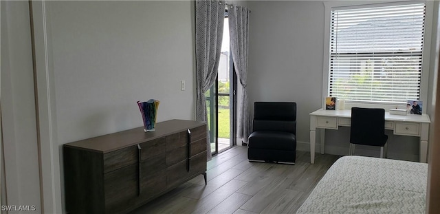 bedroom featuring built in desk and light wood-type flooring