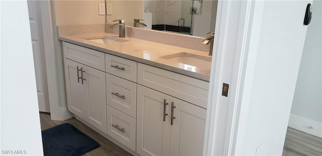 bathroom with hardwood / wood-style floors, vanity, and an enclosed shower