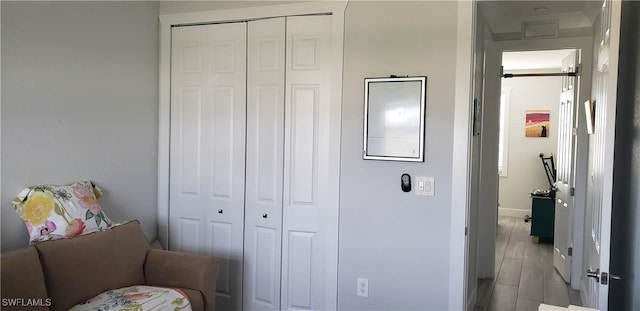 bedroom with light hardwood / wood-style floors and a closet