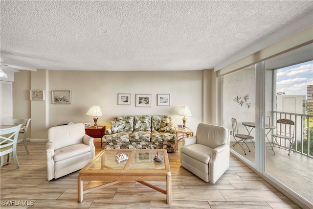 living room with ceiling fan and a textured ceiling