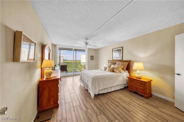 bedroom with access to exterior, ceiling fan, and a textured ceiling