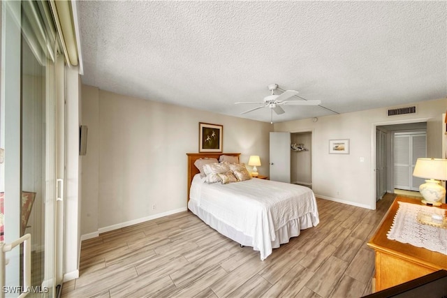 bedroom with ceiling fan and a textured ceiling