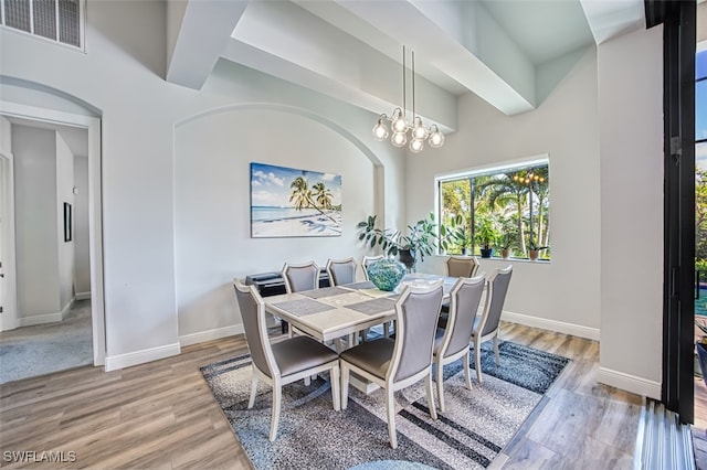 dining area with hardwood / wood-style flooring and an inviting chandelier