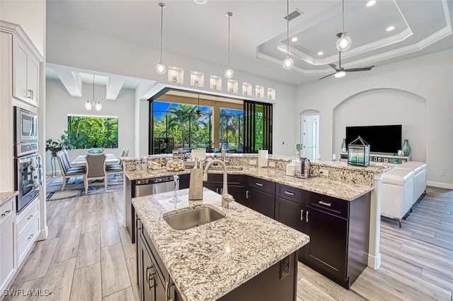 kitchen featuring stainless steel appliances, white cabinetry, and a kitchen island with sink