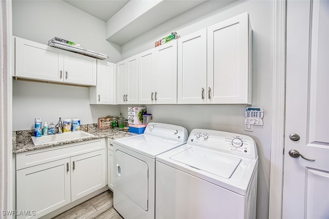 laundry room with cabinets, washing machine and dryer, and sink