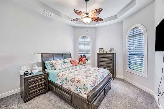 bedroom featuring a tray ceiling, ceiling fan, and light colored carpet