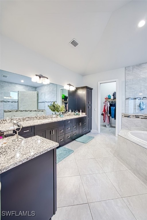 bathroom featuring plus walk in shower, vanity, and vaulted ceiling