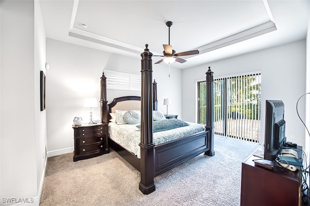 carpeted bedroom with access to outside, a raised ceiling, and ceiling fan