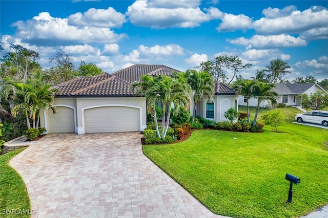 mediterranean / spanish home featuring a garage and a front lawn