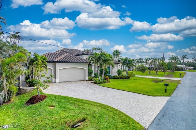 mediterranean / spanish home featuring a front lawn and a garage