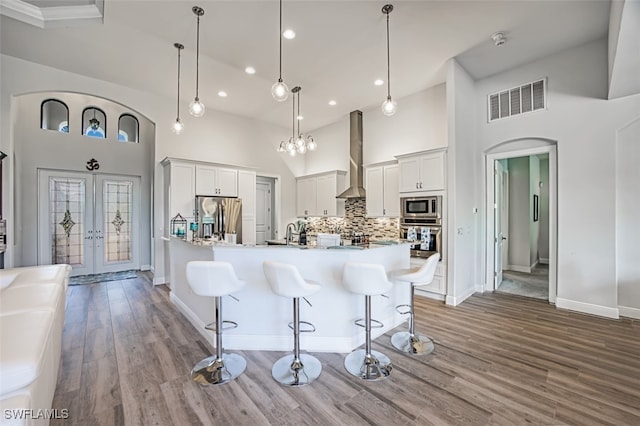 kitchen with appliances with stainless steel finishes, backsplash, hanging light fixtures, and a large island