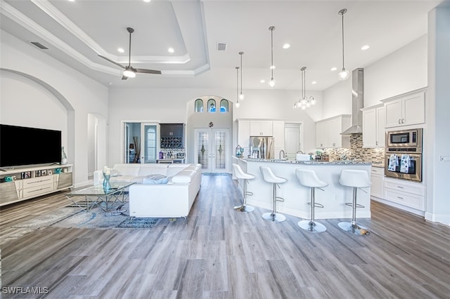 kitchen with a spacious island, decorative backsplash, appliances with stainless steel finishes, white cabinetry, and a breakfast bar area