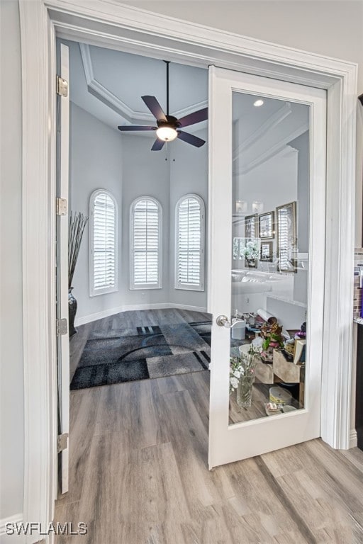 interior space with hardwood / wood-style flooring, ceiling fan, ornamental molding, and french doors